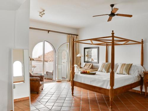 贝莱斯B Bou Hotel Cortijo Bravo的一间卧室配有一张床和吊扇
