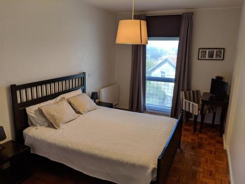 波尔图波尔图孟山多公寓的一间卧室设有一张大床和一个窗户。