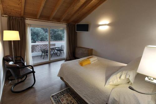 奥德米拉Quinta do Chocalhinho Agroturismo & SPA的一间带一张床和一把椅子的卧室以及一个阳台