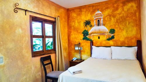 San LuisArgueta Hotel的卧室配有一张床,墙上设有钟楼