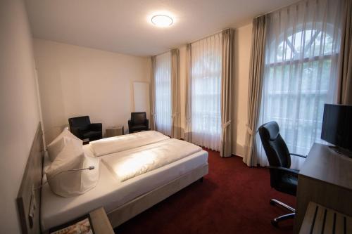 林根阿尔特斯酒店的酒店客房带床、椅子和窗户