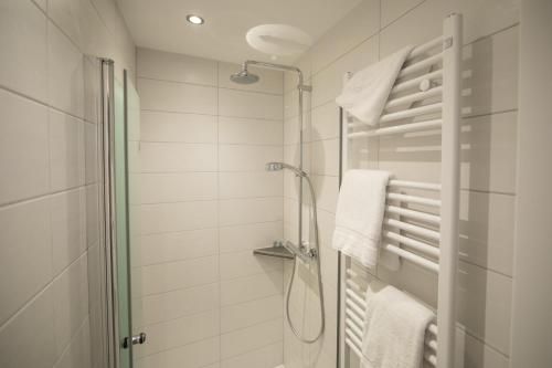 林根阿尔特斯酒店的带淋浴和毛巾的白色浴室