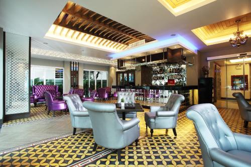 曼谷奇莱克斯度假酒店 - SHA Extra Plus的一间设有紫色椅子的餐厅和一间酒吧