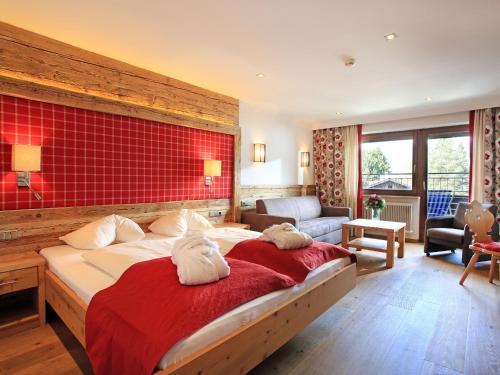 蒂罗尔-基希贝格亚历山大酒店的一间卧室设有一张大床和红色的墙壁