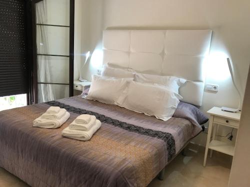 贝纳阿维斯Penthouse Karina Los Arqueros的一间卧室配有一张床,上面有两条毛巾