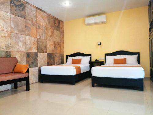伊萨马尔Departamentos X`Kanlol的酒店客房,配有两张床和椅子