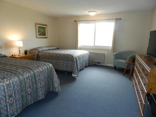 克莱顿C-Way Resort的酒店客房设有两张床和电视。