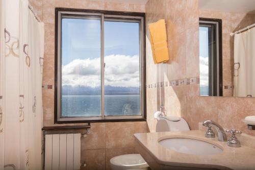 圣卡洛斯-德巴里洛切Hospedaje Penthouse 1004的一间带水槽和卫生间的浴室以及窗户。