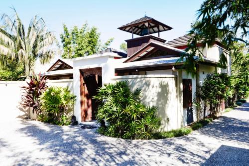 拜伦湾拜伦别墅度假村的一座白色的房子,有门和棕榈树
