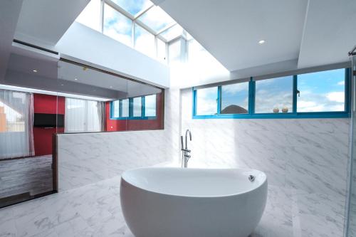 鹅銮鼻垦丁沈家地中海馆的一间带大型白色浴缸和窗户的浴室