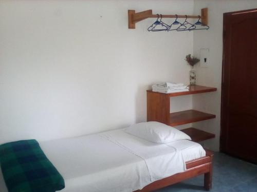 比亚米尔港Hospedaje Sarita的卧室配有白色的床和架子