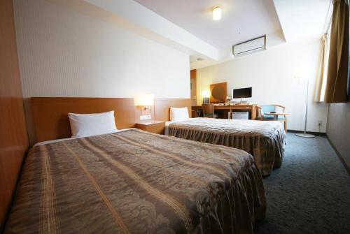 名古屋Hotel Landmark Nagoya的酒店客房配有两张床和一张书桌