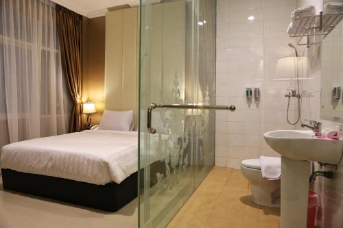 雅加达55号酒店的带淋浴、床和盥洗盆的浴室
