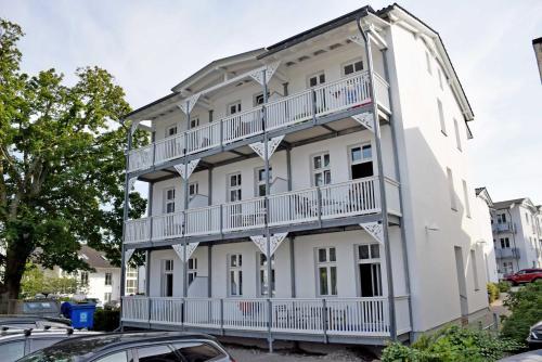 奥斯特巴德·哥伦Ferienwohnung mit Meerblick und Sauna的带阳台的白色建筑