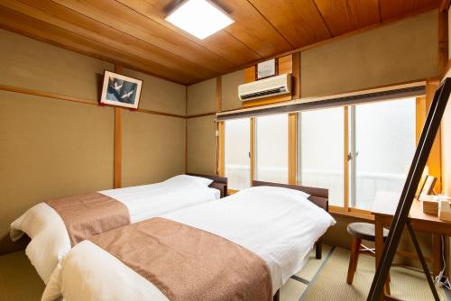 京都JPRESERVE Nakatonodacho的带窗户的客房内的两张床