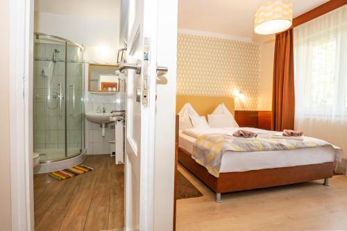 豪伊杜索博斯洛派维尔酒店的一间卧室配有一张床,浴室设有淋浴。