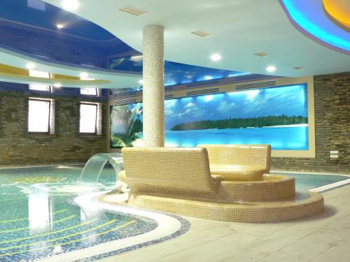 日托米尔突突温泉酒店的一个带两把椅子和大屏幕的游泳池