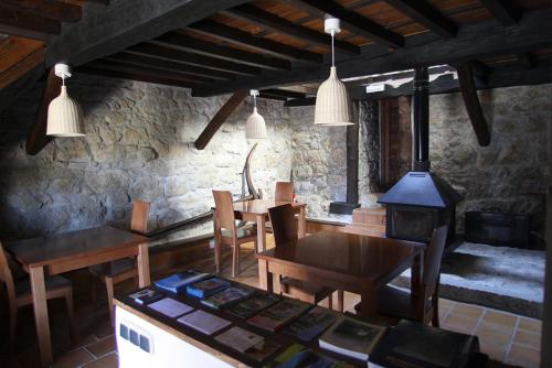 TaranesHotel Rural Llerau的一间带桌子和炉灶的用餐室