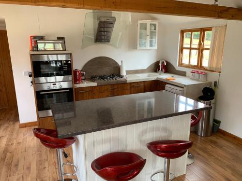 HorspathStable lodge 2 Bedrooms的厨房配有柜台和红色凳子