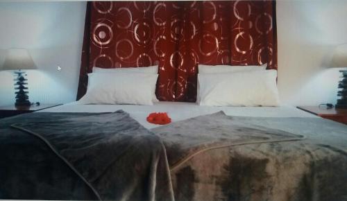普拉兰大安塞区Destination Self-Catering的一间卧室配有一张大床和红色床头板