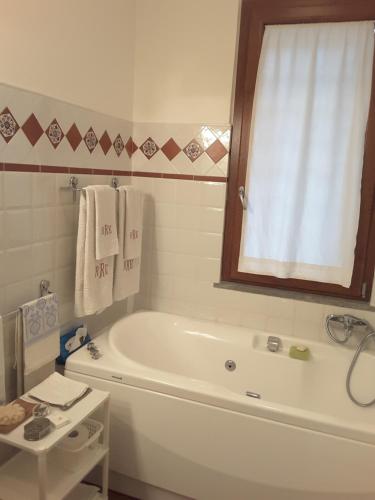 卡斯蒂里昂纳·德拉佩Primo Sole的带浴缸、窗户和毛巾的浴室
