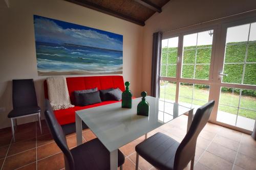 里瓦德奥Casa Veigadaira的一间带桌子和红色沙发的用餐室