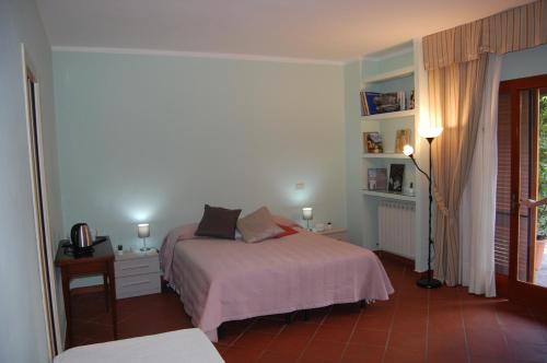 圣朱利亚诺-泰尔梅Affittacamere Loretta的一间卧室配有一张床、一张桌子和一个窗户。