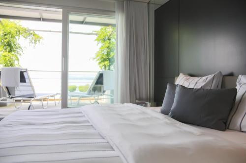 拉亨拉亨滨海酒店的卧室设有一张大白色的床和大窗户