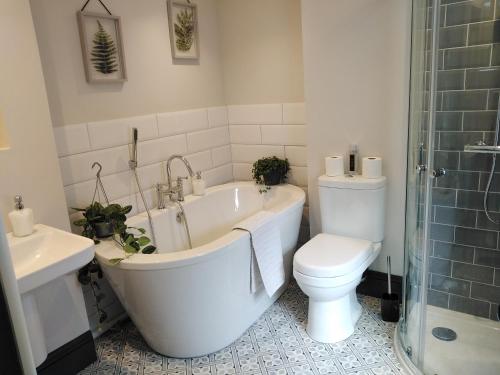 考布里奇Aubrey Cottage的带浴缸、卫生间和盥洗盆的浴室