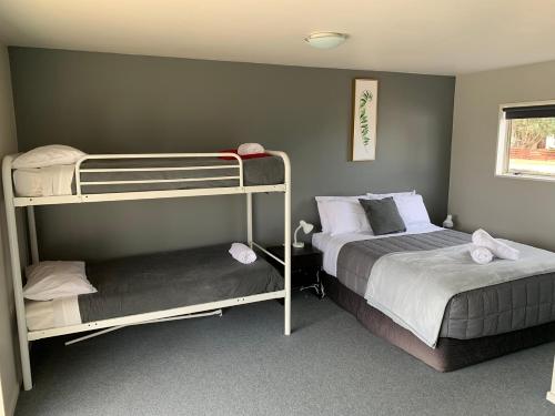 Ranfurly兰夫利假日公园及汽车旅馆 的一间卧室配有两张双层床和一张床