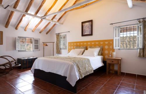伊斯纳哈尔Caseria De San José的一间卧室设有一张大床和窗户。