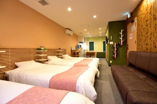 京都サクラストーリー的酒店客房,设有四张床和一张沙发