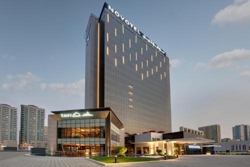 沙迦Novotel Sharjah Expo Centre的一座大建筑,上面有标志