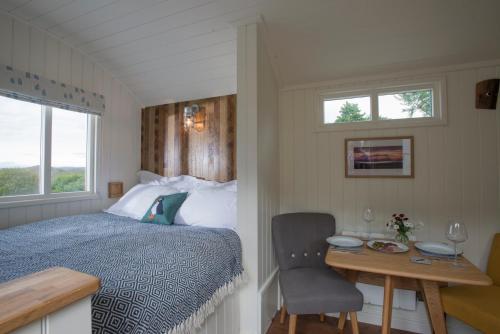 NeddWest Coast Hideaways的一间卧室配有一张床和一张桌子及椅子