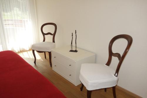 巴塞尔Exclusive Central Apartment的卧室配有两把椅子、梳妆台和床。