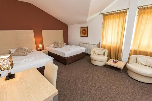 比耶洛波列多米纳斯酒店的酒店客房带两张床和一张桌子以及椅子。