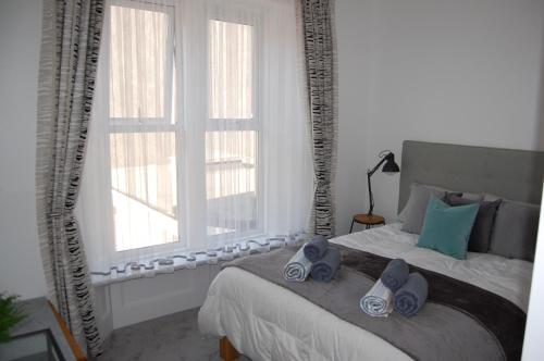 滨海韦斯顿Central Living Apartment的一间卧室配有一张带蓝色毛巾的床