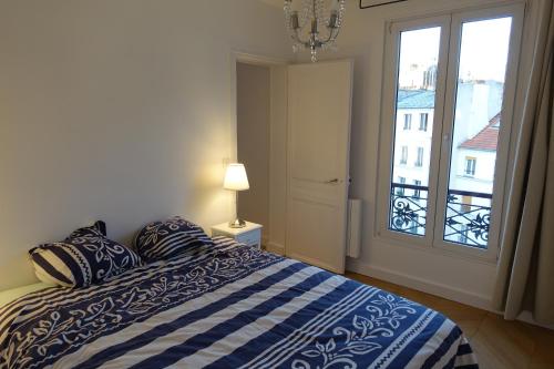 巴黎Sunny and quiet apartment的一间卧室设有一张床和一个美景窗户。