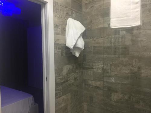 切萨雷奥港Hotel Riva Del Sole的浴室的毛巾挂在墙上