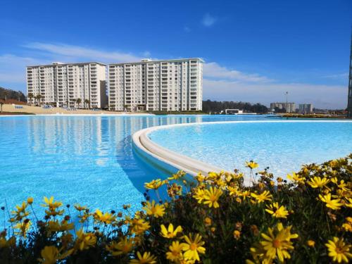 阿尔加罗沃Departamento en Laguna Bahia的一个蓝色的海水和黄色的花卉的大型游泳池