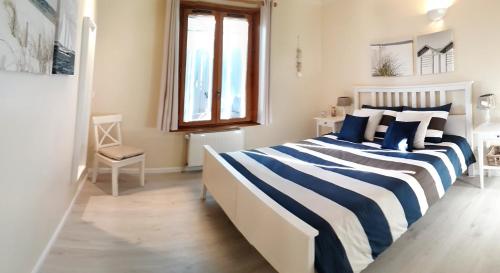 蒙夫朗屈安Gîte Les Volets Bleus的一间卧室配有一张蓝色和白色条纹的床
