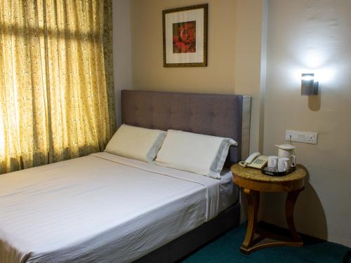 巴西古当福拉瑞酒店的一间卧室配有一张床,桌子上配有电话