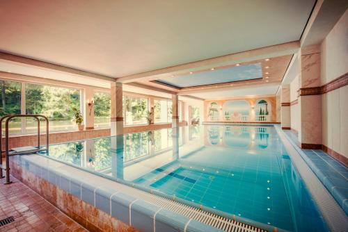 弗罗伊登施塔特兰根沃德湖酒店的一座带大窗户的房屋内的室内游泳池