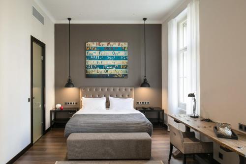 布拉格Quentin Prague Hotel的一间卧室配有一张大床和一张书桌