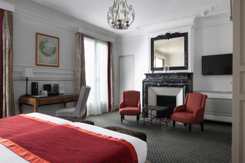 巴黎阿斯托利亚布拉德福德酒店的一间卧室配有一张床、一张桌子和一个壁炉