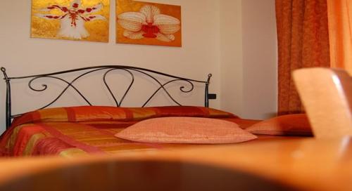 索拉纳B&B La Ca Vecia的一间卧室配有红色和橙色枕头的床