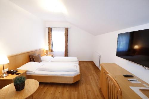 萨尔察赫河畔戈灵麦尔咖啡店旅馆 的配有一张床和一台平面电视的酒店客房