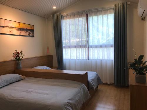恩施恩施大峡谷春伦农家乐的一间卧室设有两张床和窗户。