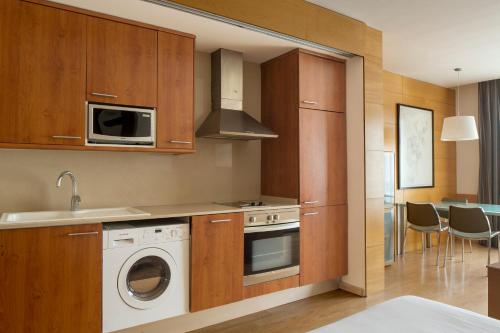 巴塞罗那韦洛公寓的厨房配有洗衣机和微波炉。