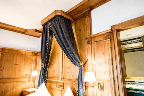 修希艾西安基希亚娜酒店的一间卧室设有木墙,床配有窗帘